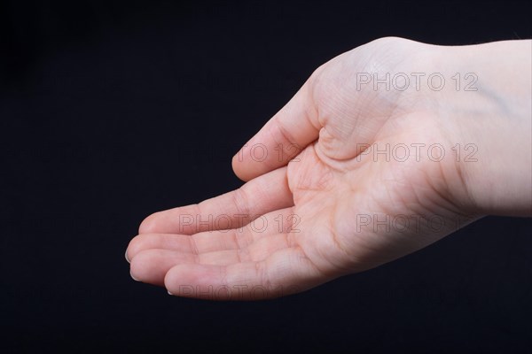 Five fingers of a child hand partly seen in black background