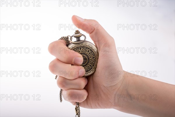 Hand holding a retro styled pocket watch in hand