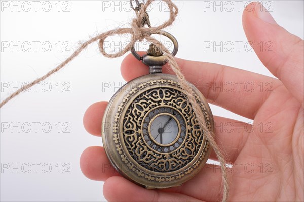 Retro style pocket watch in hand on white background