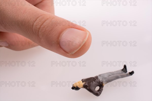 Hand threating to smash human figure on a white background