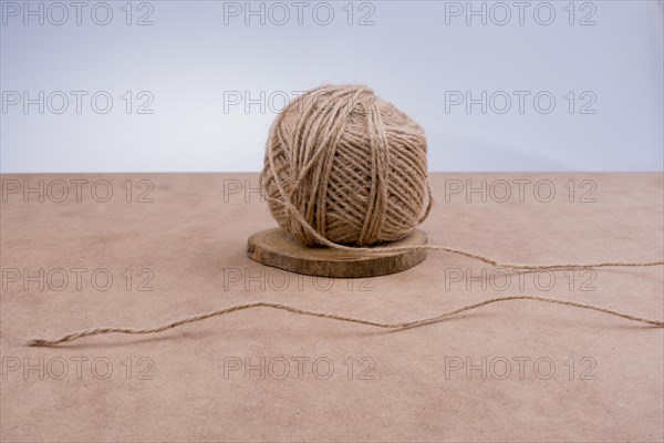 Roll of brown color linen string on brown background