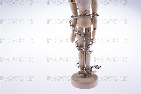 Wooden model man in chains on a white background