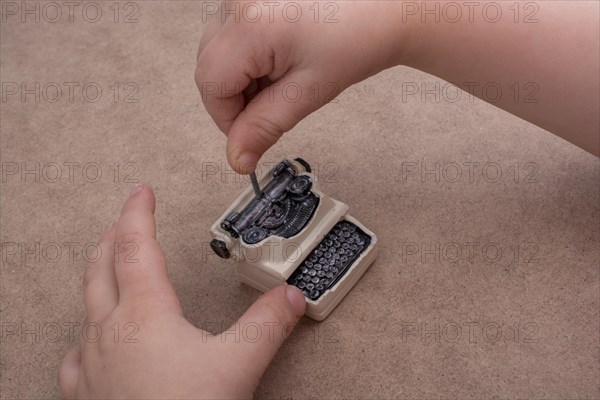 Hand holding a retro syled mini typewriter model