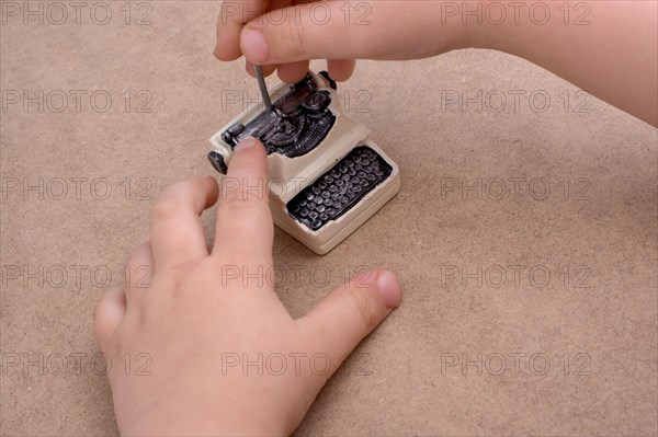 Hand holding a retro syled mini typewriter model