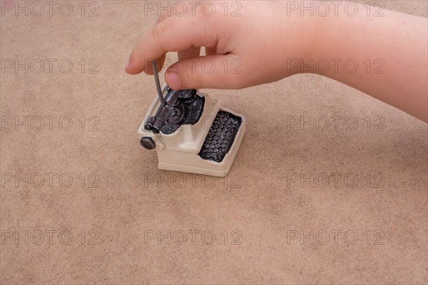 Hand holding a retro syled mini typewriter model