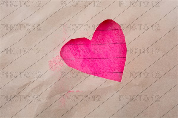 Hole made in lined paper on the form of a heart