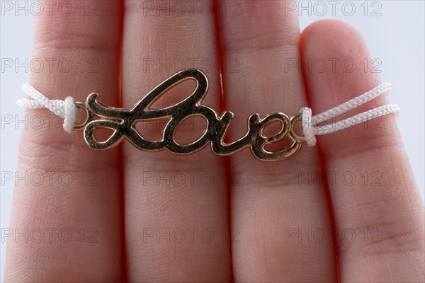 Love written with l letters made of metal in hand