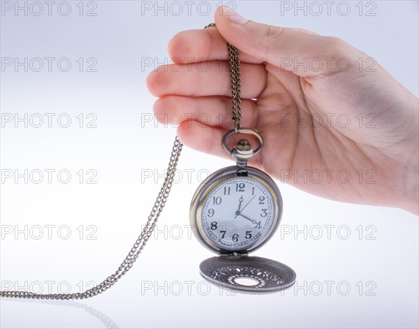 Hand holding a retro styled pocket watch in hand