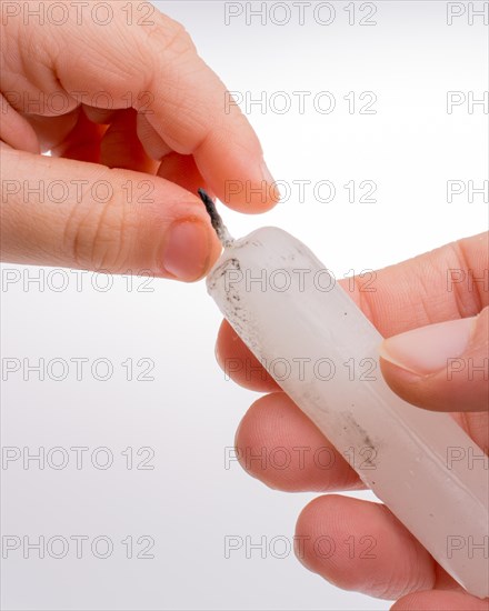 White candle stick in hand on a white background