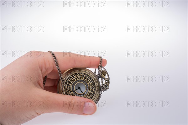 Retro style pocket watch in hand on white background