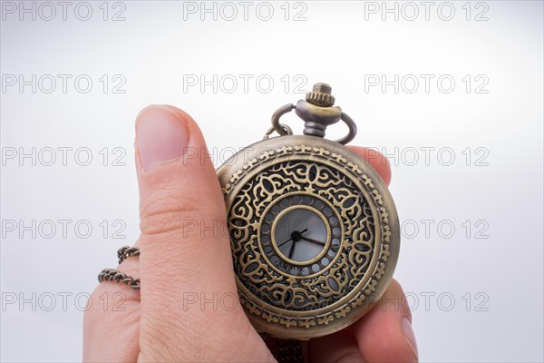 Retro style pocket watch in hand on white background