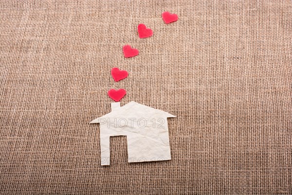 Heart shape coming out of chimney of paper house