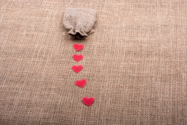 Heart shaped objects before a sack on canvas