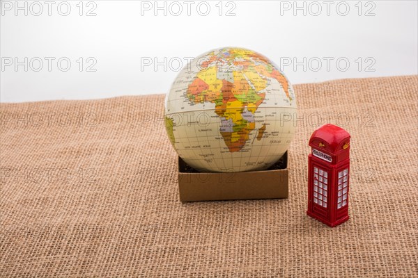 Globe with a telephone booth on canvas background