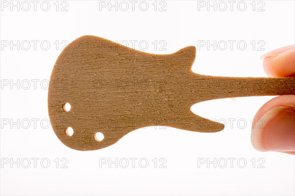 Mini wooden guitar model in hand on a white background