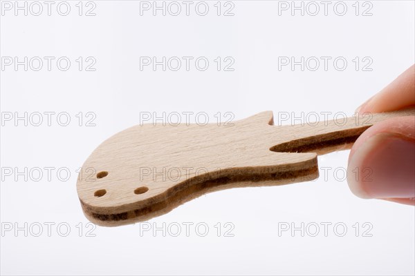 Mini wooden guitar model in hand on a white background