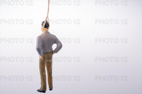 Man figurine tied with aa rope on a brown backgorund