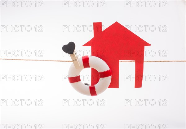 Model house and a life preserver with a heart on a string