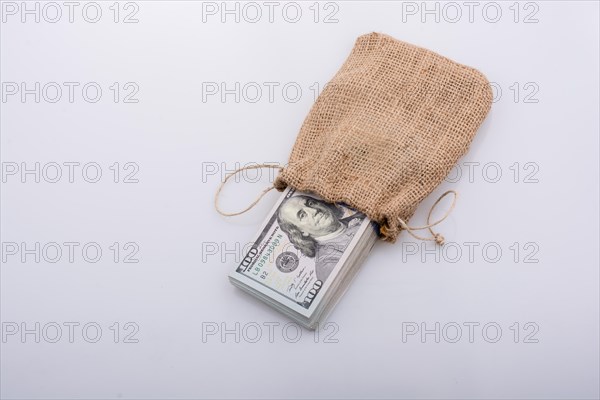 Banknote bundle of US dollarin a sack on a white background