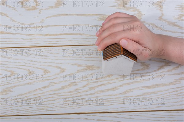 Little model housein hand on a parquet background