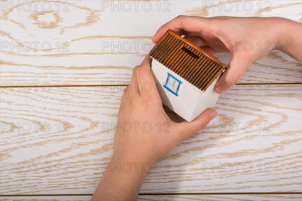 Little model housein hand on a parquet background