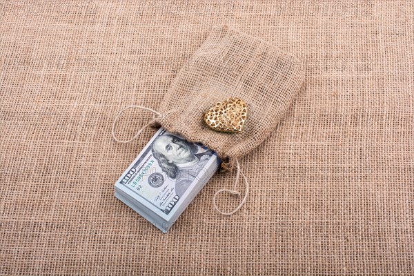 Heart icon bundle of US dollar placed on a linen canvas