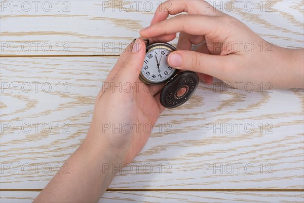 Retro style pocket watch in hand on black background