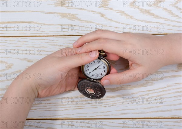 Retro style pocket watch in hand on black background