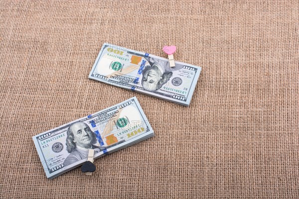Heart icon bundle of US dollar placed on a linen canvas