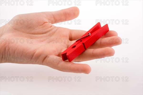 Hand holding a red clothespin on a white background