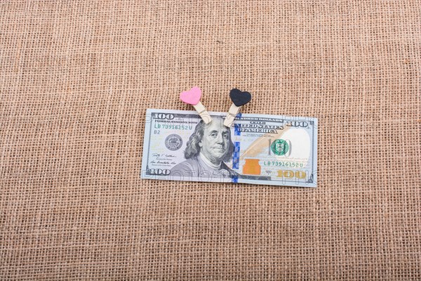Heart icon bundle of US dollar placed on a linen canvas
