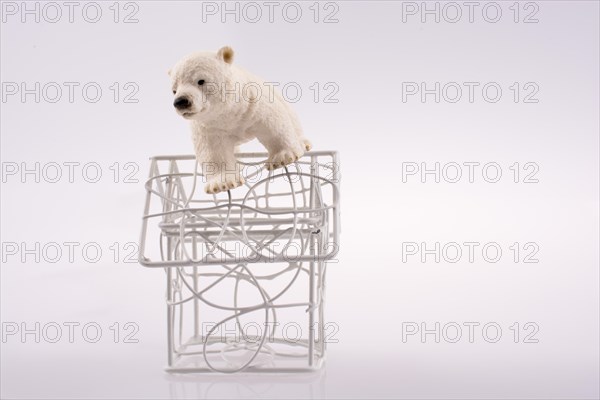 Polar bear cub on the roof of a model house mado of roof