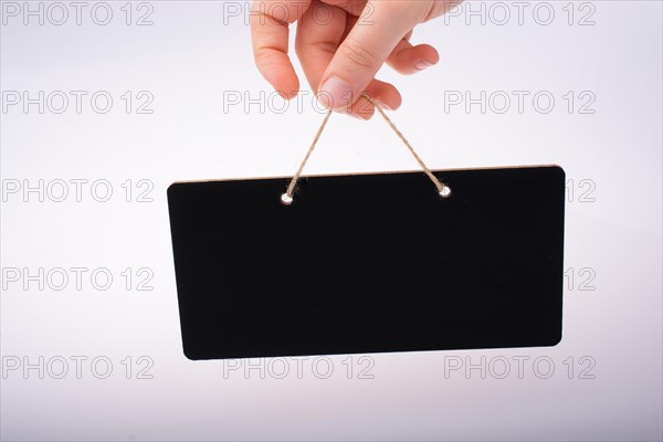 Rectangular shaped black notice board in hand on white background