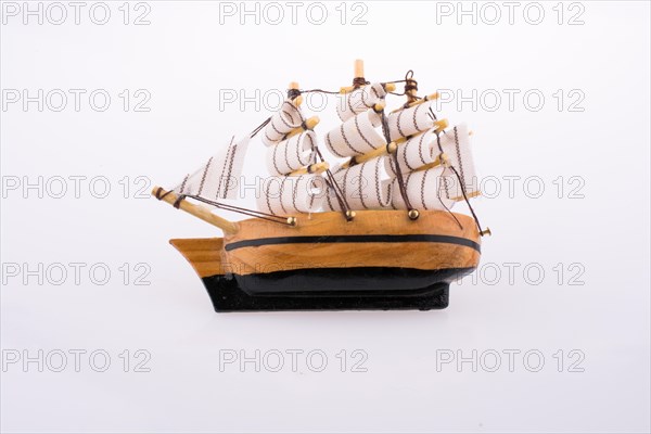 Little wooden model sailboat on white background