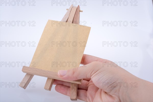 Brown color notepaper on a painting tripod in hand