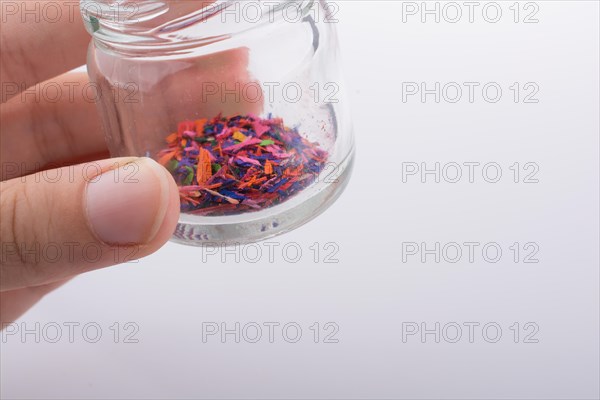 Little perfume glass bottle in hand on a white background