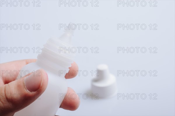 White empty dropper bottle in hand on a white background