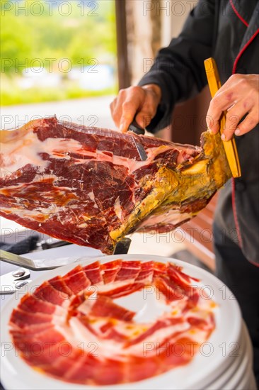 Detail of a man cutting Iberian ham at a wedding