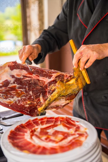 Detail of a man cutting Iberian ham at a wedding