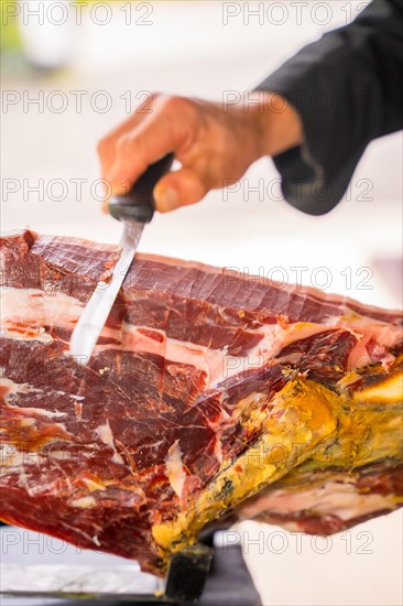 Detail of a man cutting Iberian ham at a wedding or event