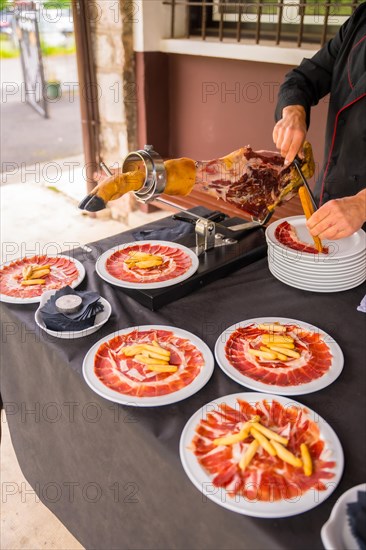 Detail of a man cutting Iberian ham at a wedding or event