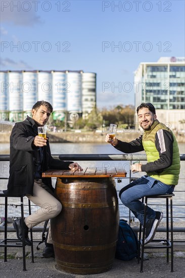 Two friends drinking and toasting with beer at pub brewery