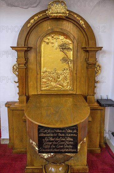 Baptismal font with metal relief