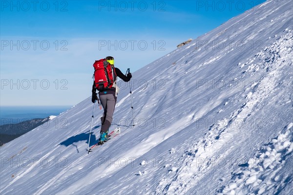 A female ski tourer on a mountain slope on her way to a summit in the Karwendel Mountains