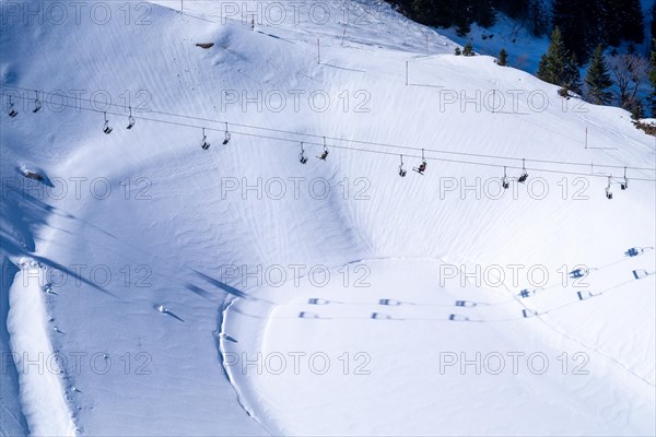 Skiers in the chairlift over a frozen and snow-covered reservoir