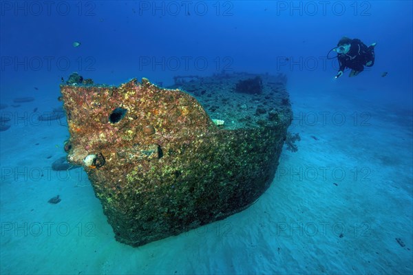 Diver looks at hull of small wreck Shipwreck Emily off the north coast of Mauritius near Grand Baie