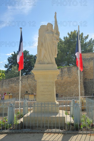 Monument with white statue with sword and two French national flags