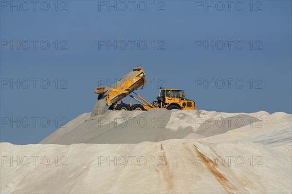 Dump truck unloading salt at a salt mine for salt extraction