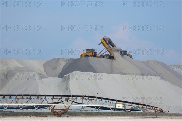 Dump truck unloading salt at a salt mine for salt extraction