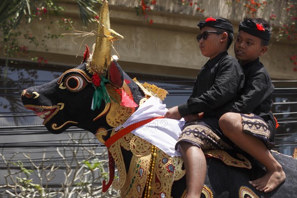 Two boys sitting on a bull